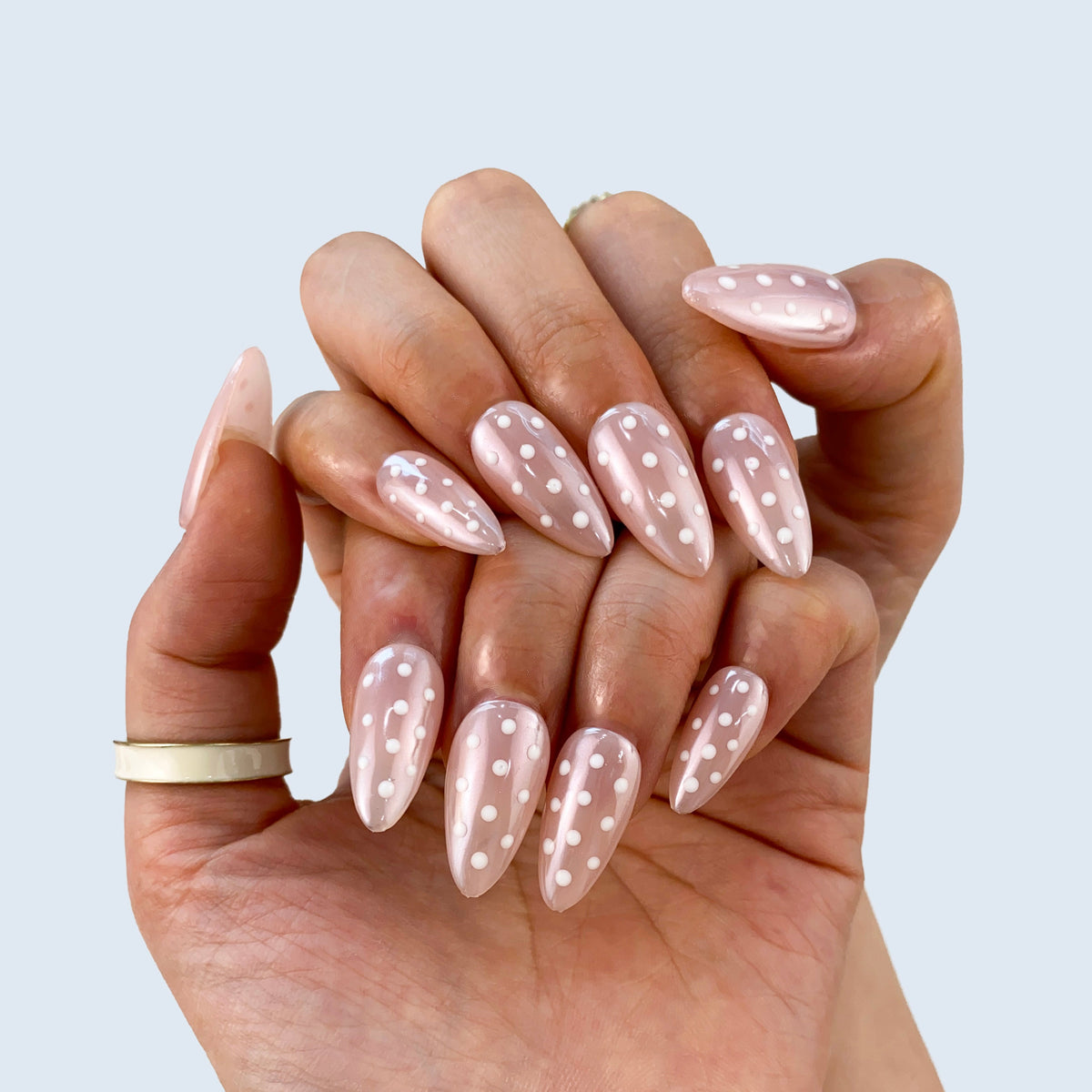 Angled view of Polka Muse almond nails displaying glossy sheer jelly finish