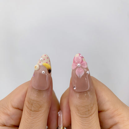Thumbs closeup of Harajuku Sugar nails showing 3D sculpted banana and flower art