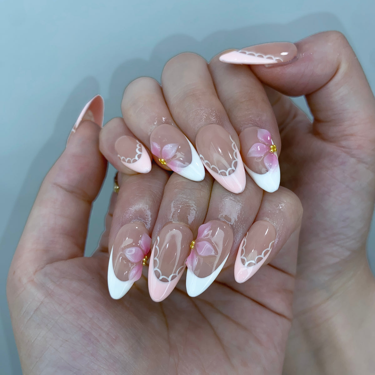 On-hand try-on of Ballet Bloom almond press-on nails showing pink floral art