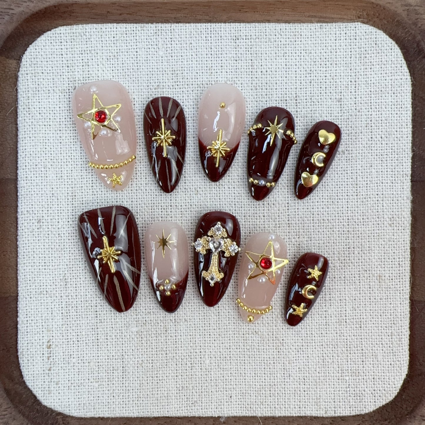 Flat lay photo of Gothic Romance nails on white linen displaying 3D crystal cross