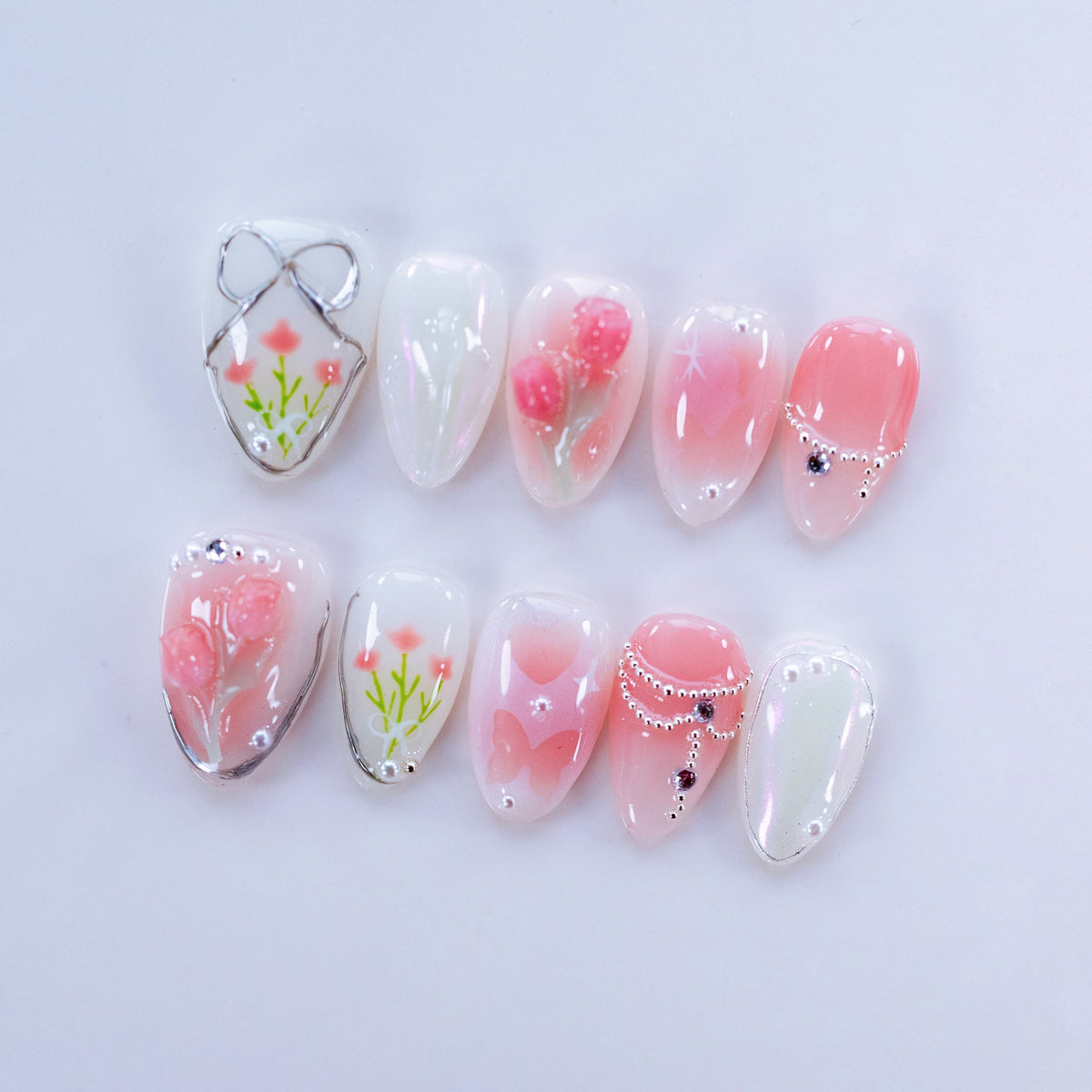 Flat lay photo of Fairy Love Story nails showing 3D sculpted tulips and wire bows